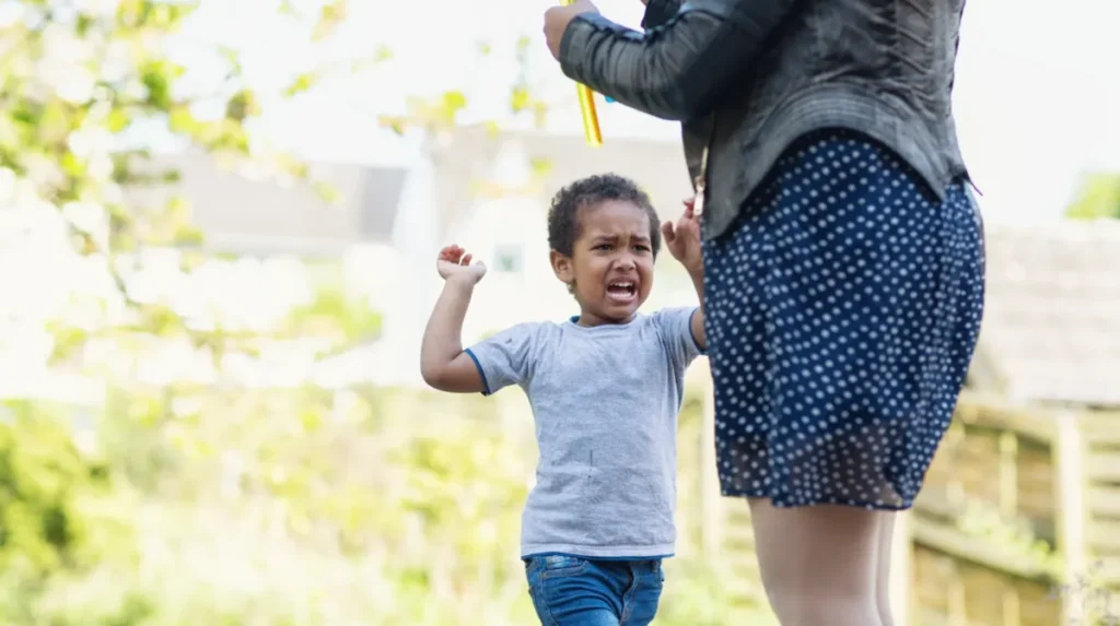 Mãe brincando com filho para desviar atenção de uma frustração das birras.