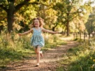 Criança correndo feliz em um parque arborizado sob a luz do sol.